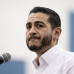 Close up of Abdul El-Sayed in a white shirt with open collar.