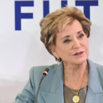 Linda McMahon looks on.