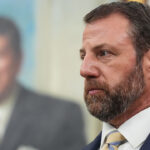 Marwayne Mullin looks on.
