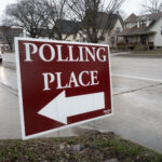 A sign reading POLLING PLACE, drawing the reader to consider the poll taken this month that indicates Alfonso's lead.