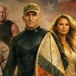A group of serious-looking men and one woman stand together, some in military gear. One man in front holds a surfboard with a Texas flag design. A faded Texas flag appears in the background.
