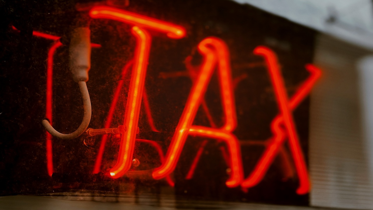 A neon sign reads taxes.