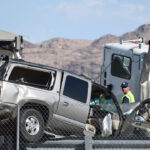Two damaged vehicles, including a silver SUV and a white truck, are surrounded by emergency workers in safety vests near a road with mountains in the background. These crashes have increased with illegal immigrants behind the wheel.