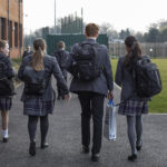 High school students head into school where they will be taught by a teacher