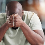 Man praying the rosary.
